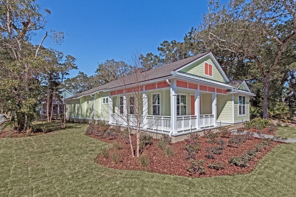 Example of a mid-sized beach style green one-story wood house exterior design in Jacksonville with a hip roof and a shingle roof
