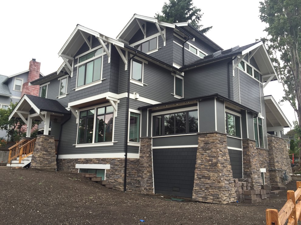 Großes, Dreistöckiges Rustikales Haus mit Vinylfassade, grauer Fassadenfarbe und Satteldach in Seattle