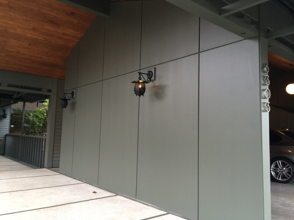Mittelgroßes Modernes Haus mit Metallfassade, grüner Fassadenfarbe und Flachdach in Seattle
