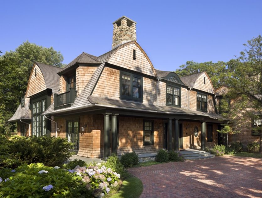 Cette photo montre une très grande façade de maison beige tendance en bois à deux étages et plus avec un toit de Gambrel et un toit en shingle.