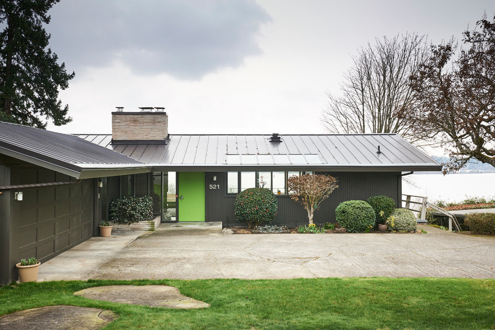 Réalisation d'une façade de maison grise vintage de taille moyenne avec un toit en métal.