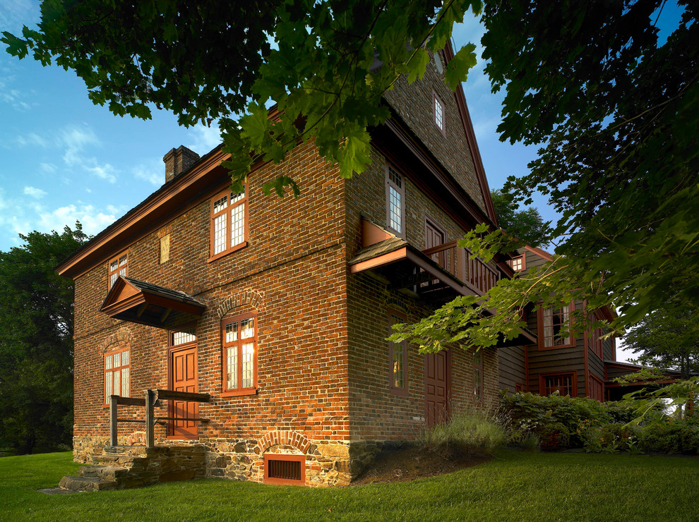 Esempio della facciata di una casa rossa country a due piani con rivestimento in mattoni