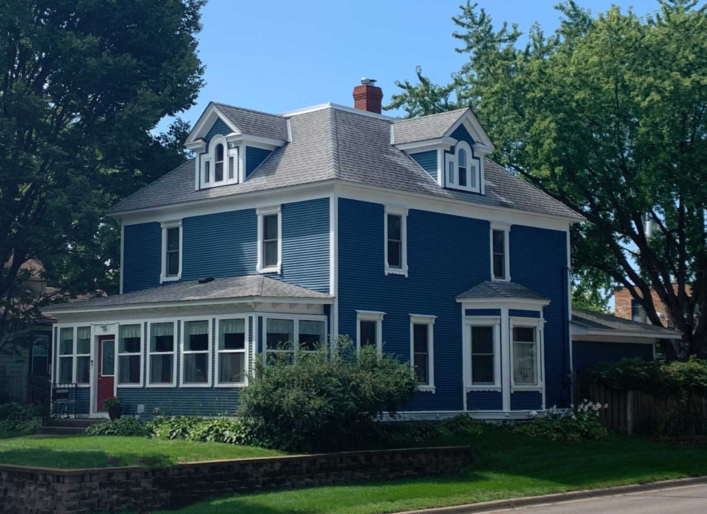 Cette photo montre une grande façade de maison bleue victorienne à deux étages et plus avec un toit à quatre pans et un toit en shingle.