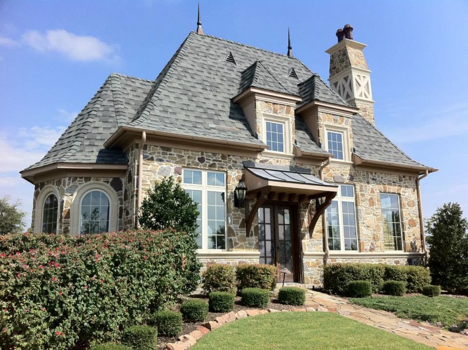 Mid-sized traditional beige two-story stone exterior home idea in Dallas with a hip roof