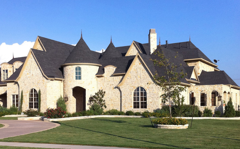 Exemple d'une grande façade de maison beige chic en pierre à un étage avec un toit à deux pans.