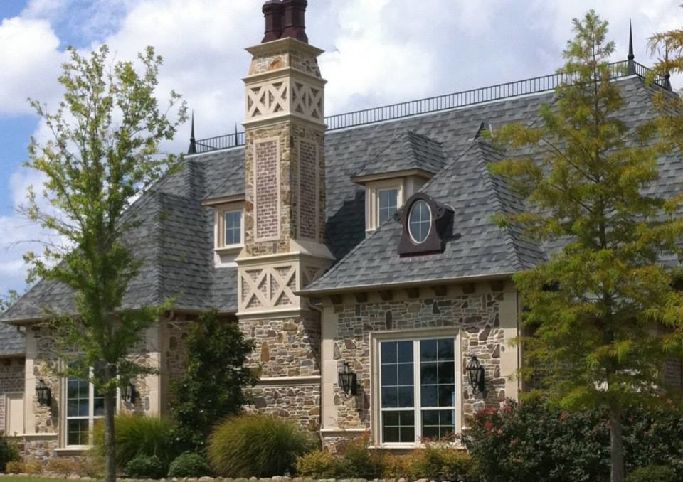 Photo of a large and beige classic two floor house exterior in Dallas with stone cladding and a hip roof.