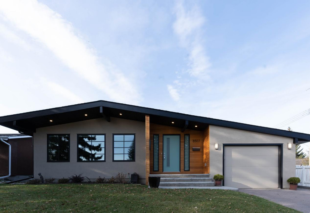 На фото: одноэтажный, серый частный загородный дом среднего размера в стиле ретро с комбинированной облицовкой и двускатной крышей