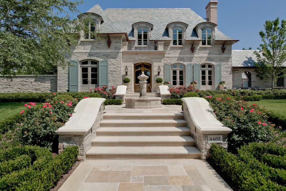 Zweistöckiges Klassisches Haus mit Steinfassade, beiger Fassadenfarbe und Walmdach in Dallas