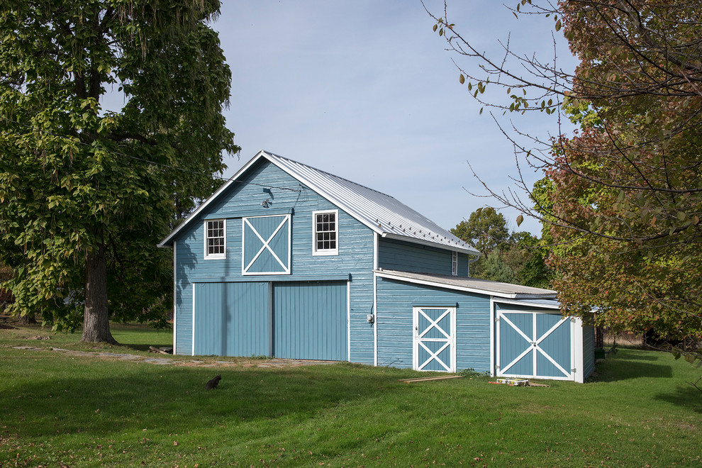 Esempio della villa blu country a due piani con rivestimento in legno, tetto a capanna e copertura in metallo o lamiera