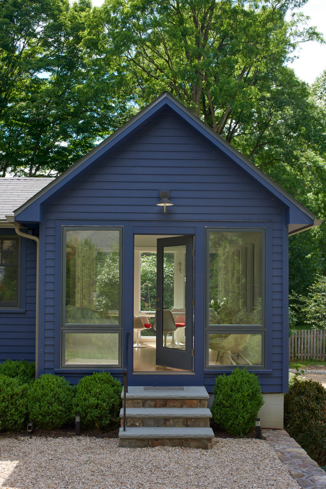 На фото: одноэтажный, деревянный, синий частный загородный дом среднего размера в стиле неоклассика (современная классика)