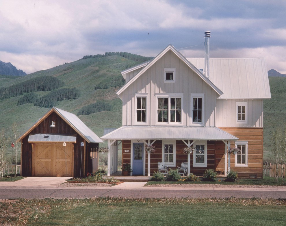 Foto della facciata di una casa piccola country a due piani con rivestimento in legno