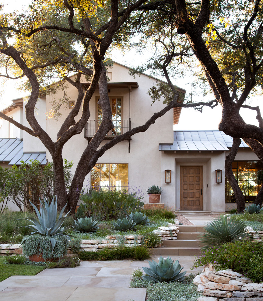 Zweistöckiges Mediterranes Haus mit beiger Fassadenfarbe und Satteldach in Austin