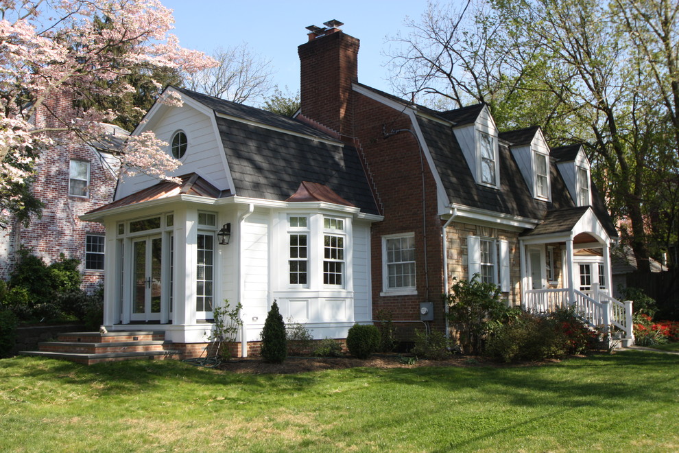 Foto de fachada blanca clásica grande de dos plantas con revestimientos combinados y tejado a doble faldón