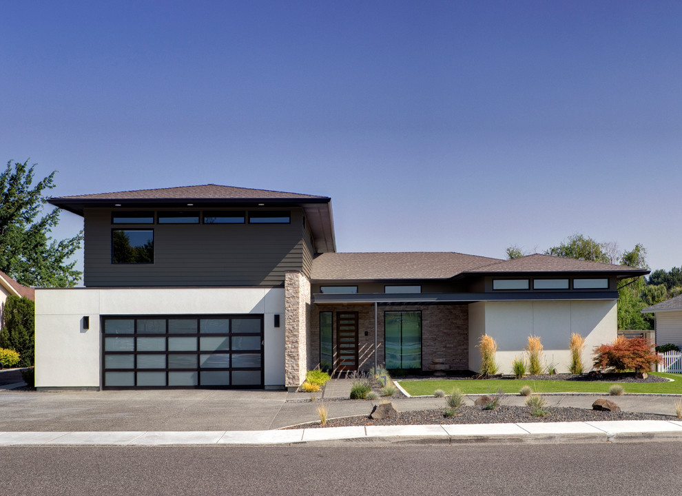 Cette image montre une façade de maison multicolore minimaliste en stuc de taille moyenne et à un étage avec un toit à quatre pans et un toit en shingle.