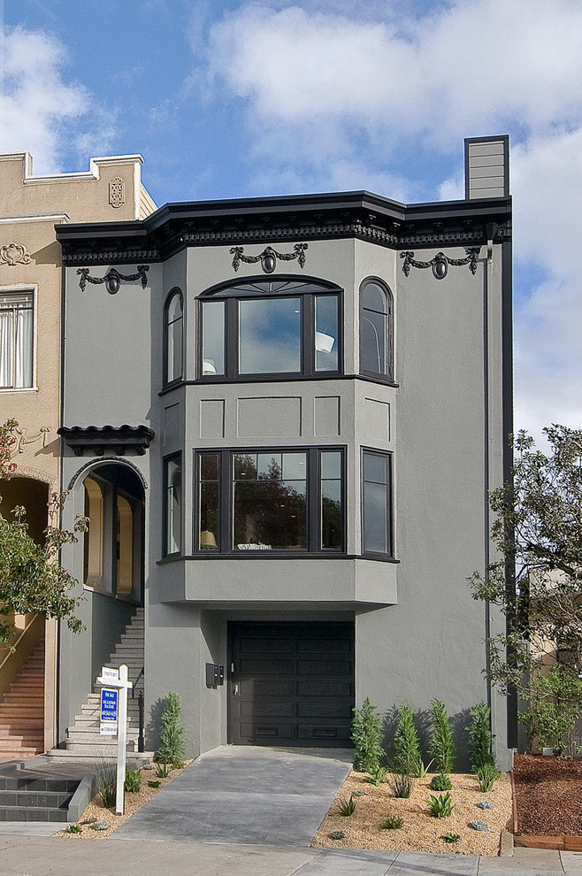 Exemple d'une grande façade de maison grise tendance en stuc à deux étages et plus avec un toit plat.