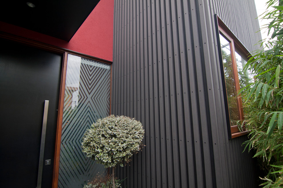 Diseño de fachada de casa pareada roja actual pequeña de dos plantas con revestimientos combinados