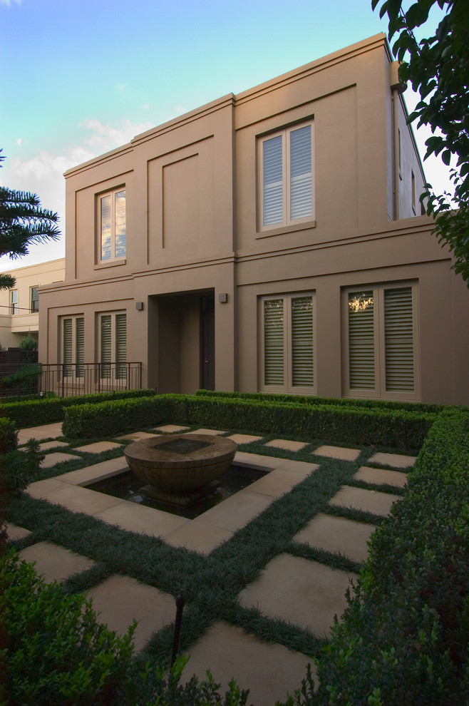 Diseño de fachada beige clásica de tamaño medio de dos plantas con revestimiento de estuco y tejado plano