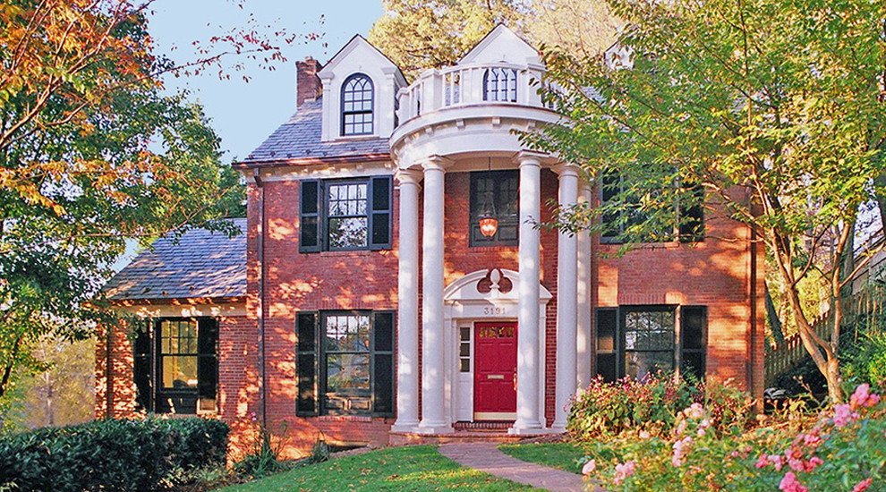 Large and red traditional brick house exterior in DC Metro with three floors and a pitched roof.