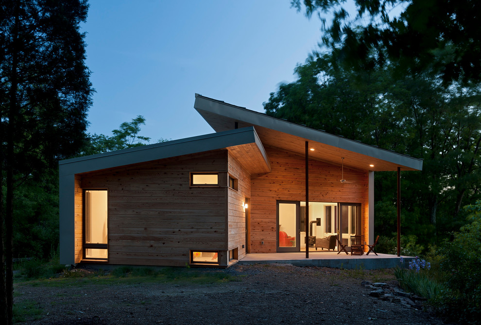 Идея дизайна: деревянный, маленький, одноэтажный, коричневый частный загородный дом в современном стиле с односкатной крышей и металлической крышей для на участке и в саду, охотников