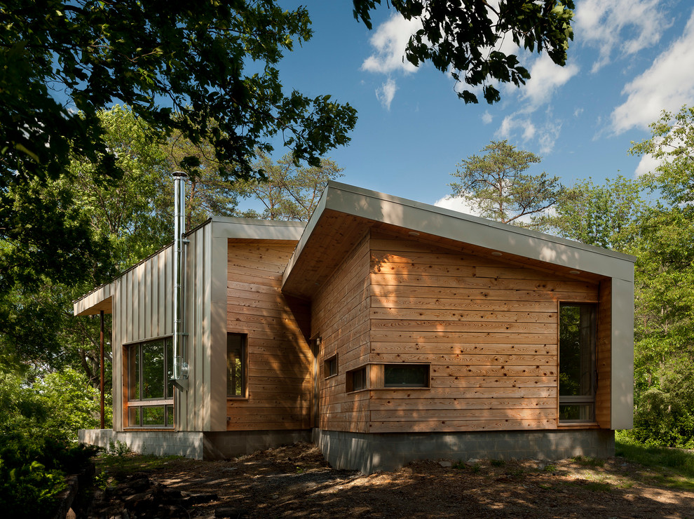 На фото: деревянный, маленький, одноэтажный, коричневый частный загородный дом в современном стиле с односкатной крышей для на участке и в саду, охотников с