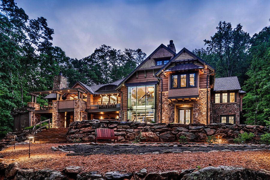 Inspiration for a large rustic brown two-story stone exterior home remodel in Other with a shingle roof