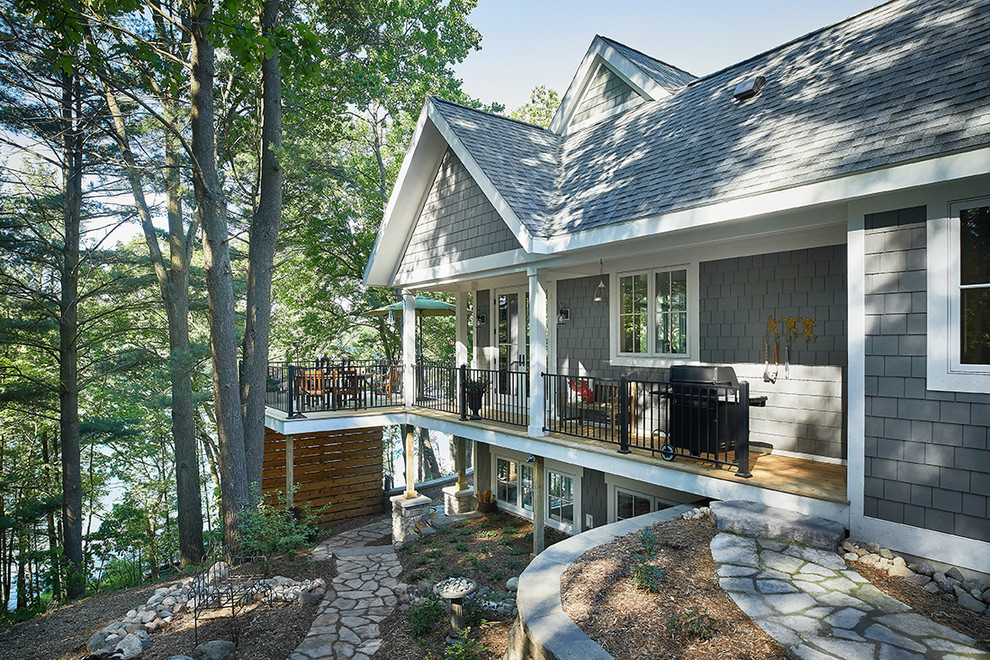 Стильный дизайн: серый частный загородный дом в современном стиле с комбинированной облицовкой, двускатной крышей и крышей из гибкой черепицы - последний тренд