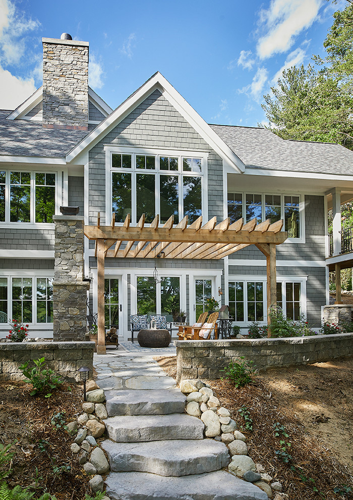 Modernes Einfamilienhaus mit Mix-Fassade, grauer Fassadenfarbe, Satteldach und Schindeldach in Grand Rapids