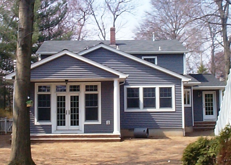 Large elegant blue two-story concrete fiberboard exterior home photo in New York with a tile roof