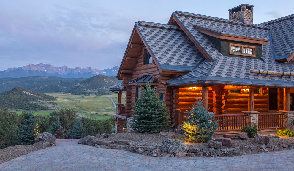 Cette image montre une grande façade de maison marron chalet en bois à un étage avec un toit à deux pans et un toit en shingle.