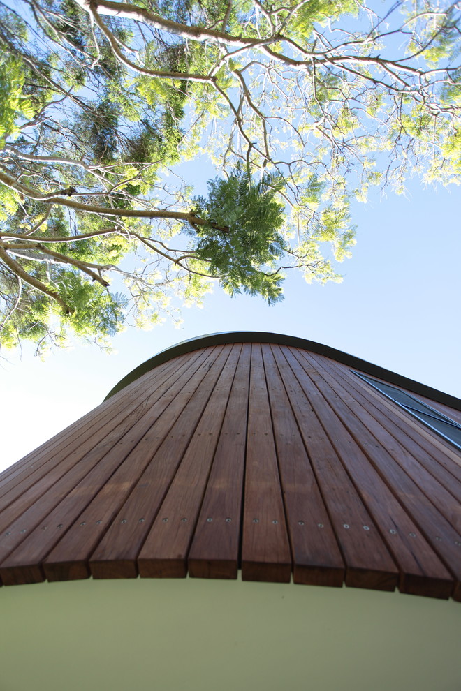 Idée de décoration pour une grande façade de maison marron design en bois à un étage avec un toit plat.