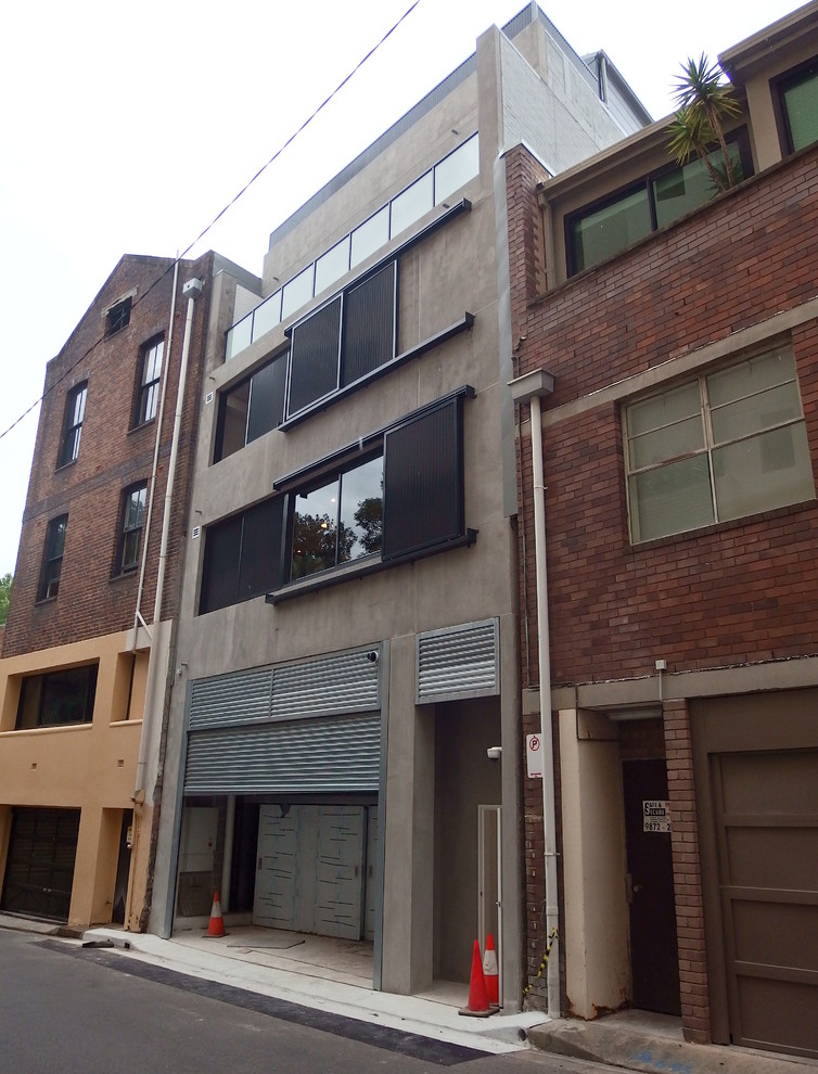 Ispirazione per la facciata di un appartamento grigio contemporaneo a tre piani di medie dimensioni con rivestimento in mattoni e copertura in metallo o lamiera