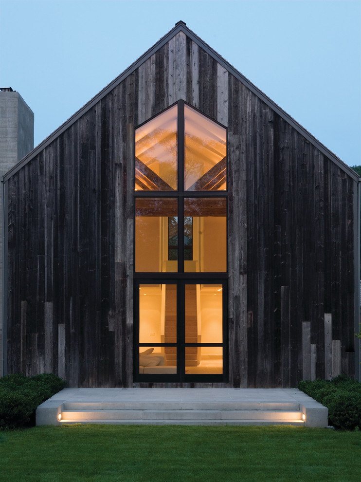 Immagine della facciata di una casa grande moderna a due piani con rivestimento in legno