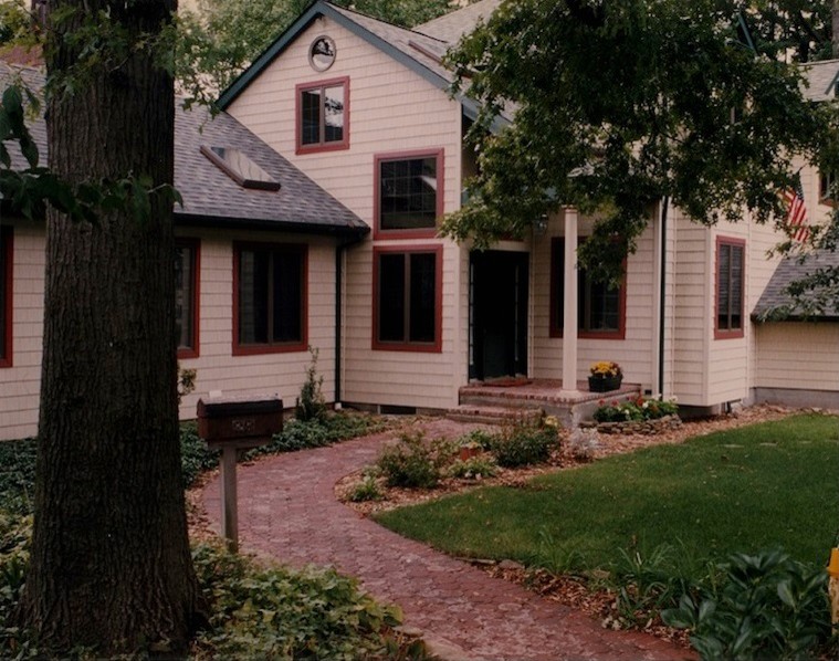 Ejemplo de fachada de estilo de casa de campo de tamaño medio de dos plantas con revestimiento de vinilo y tejado a dos aguas