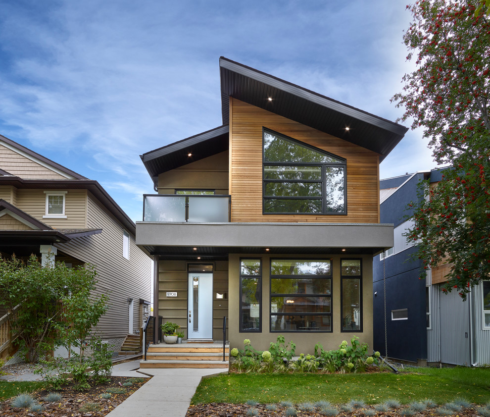 This is an example of a brown contemporary two floor detached house in Calgary with mixed cladding and a lean-to roof.