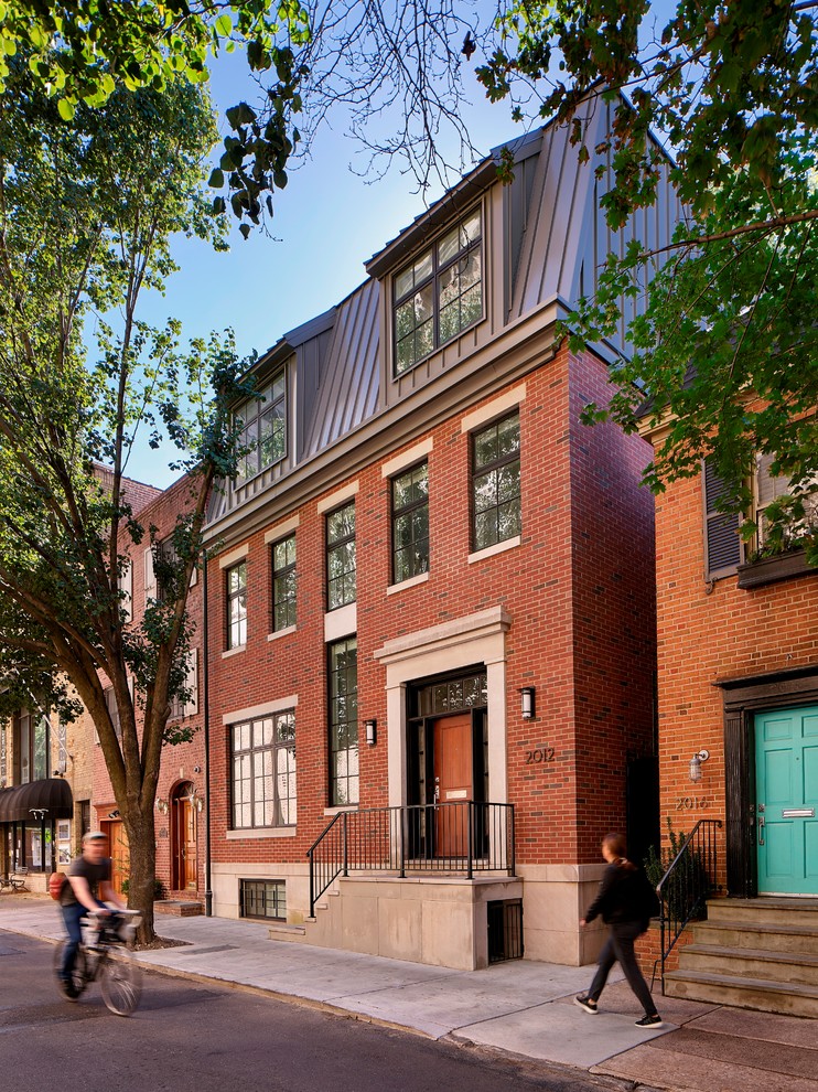 Dreistöckiges Klassisches Einfamilienhaus mit Backsteinfassade, roter Fassadenfarbe und Blechdach in Philadelphia