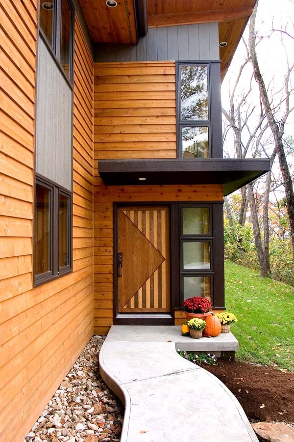 На фото: двухэтажный, деревянный, коричневый дом среднего размера в современном стиле