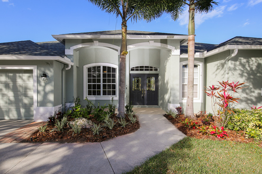 Transitional gray one-story concrete house exterior idea in Tampa with a shingle roof