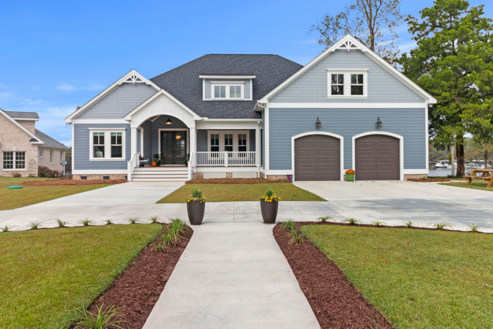 Großes, Zweistöckiges Maritimes Einfamilienhaus mit Faserzement-Fassade, blauer Fassadenfarbe, Satteldach, Schindeldach, grauem Dach und Verschalung in Raleigh