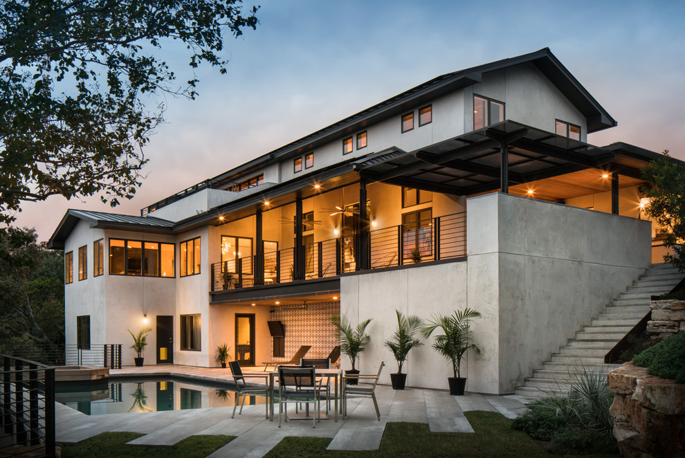 This is an example of a white contemporary house exterior in Austin with a pitched roof.