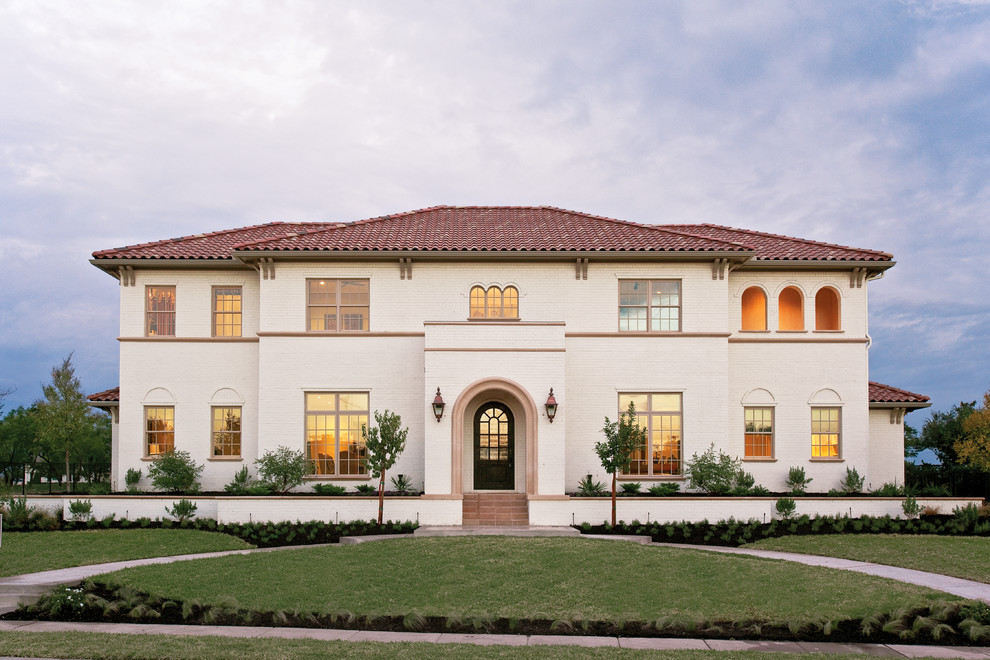 Example of a tuscan white two-story house exterior design in Dallas with a hip roof and a tile roof