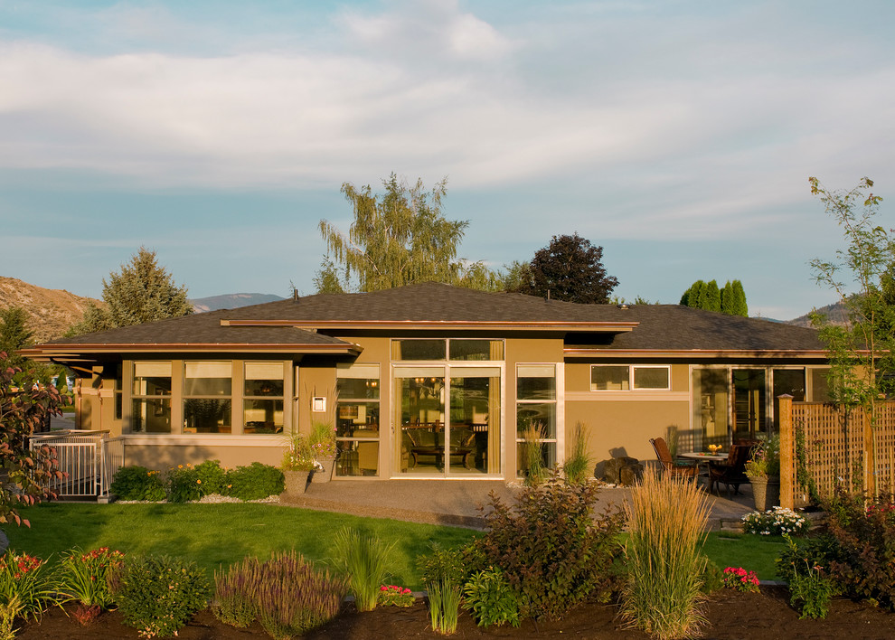 This is an example of a large and beige contemporary two floor render house exterior in Vancouver with a half-hip roof.