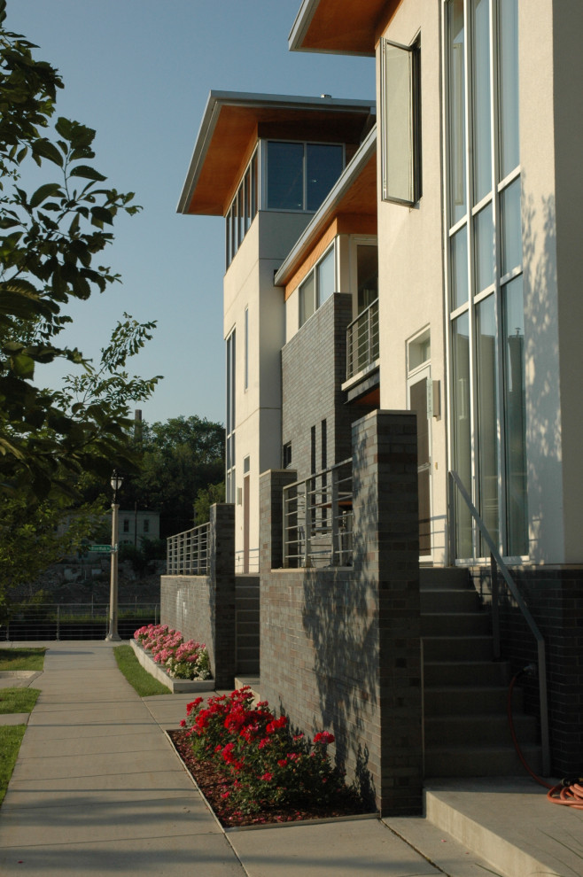 Exempel på ett stort modernt flerfärgat lägenhet, med tre eller fler plan, blandad fasad och platt tak