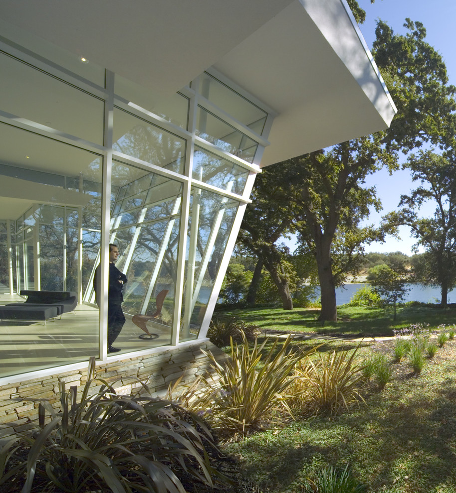 Ejemplo de fachada blanca moderna grande de una planta con revestimiento de vidrio y tejado plano