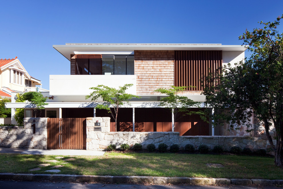 Diseño de fachada contemporánea de dos plantas con revestimientos combinados y tejado plano
