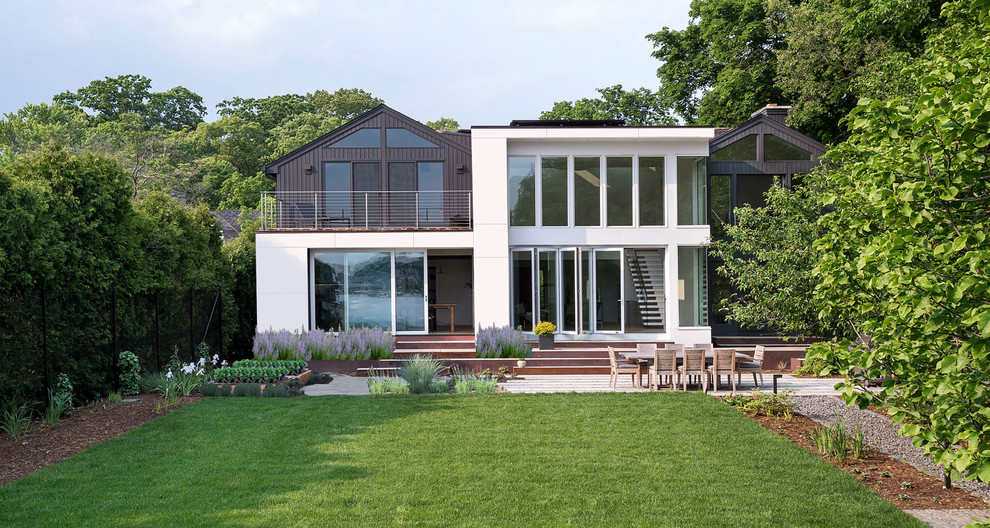 Ejemplo de fachada de casa blanca minimalista de tamaño medio de dos plantas con revestimientos combinados, tejado plano y tejado de metal