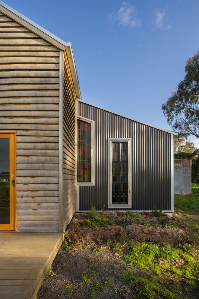 Diseño de fachada de casa ecléctica pequeña de dos plantas con revestimiento de madera, tejado a dos aguas y tejado de metal