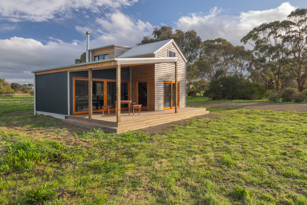 Стильный дизайн: маленький, двухэтажный, деревянный частный загородный дом в стиле фьюжн с двускатной крышей и металлической крышей для на участке и в саду - последний тренд