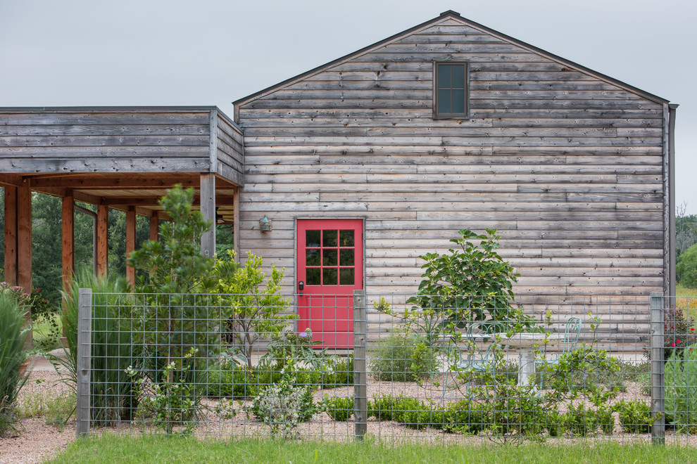 Photo of a rural house exterior in Austin with wood cladding and a pitched roof.