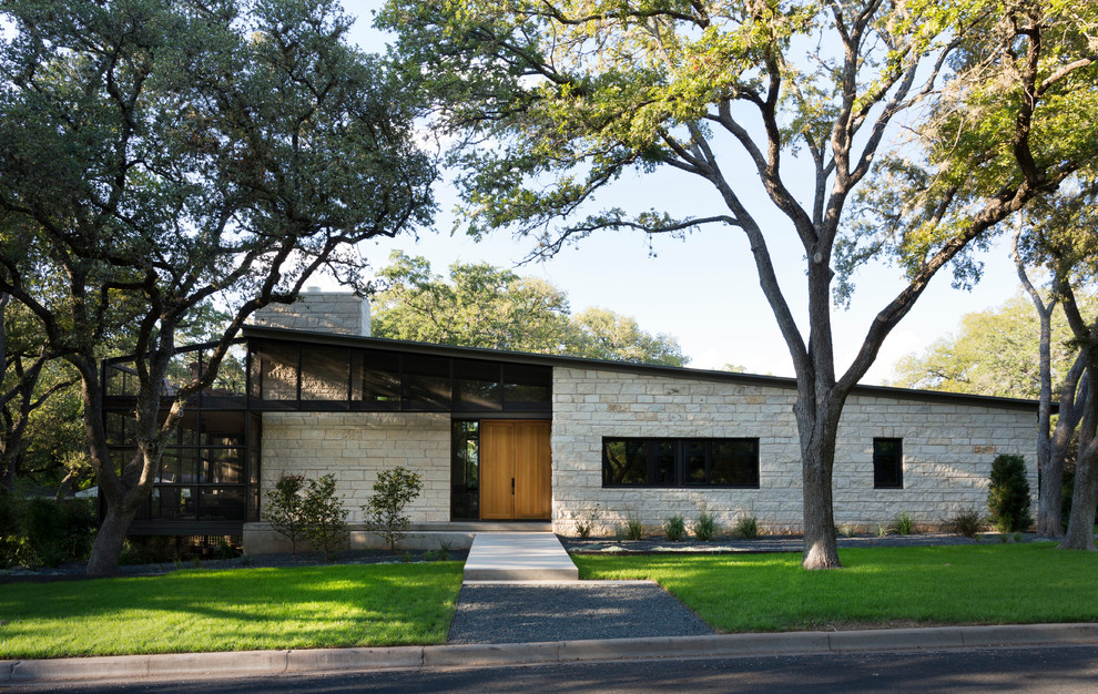 Modern bungalow house exterior in Austin with stone cladding and a lean-to roof.