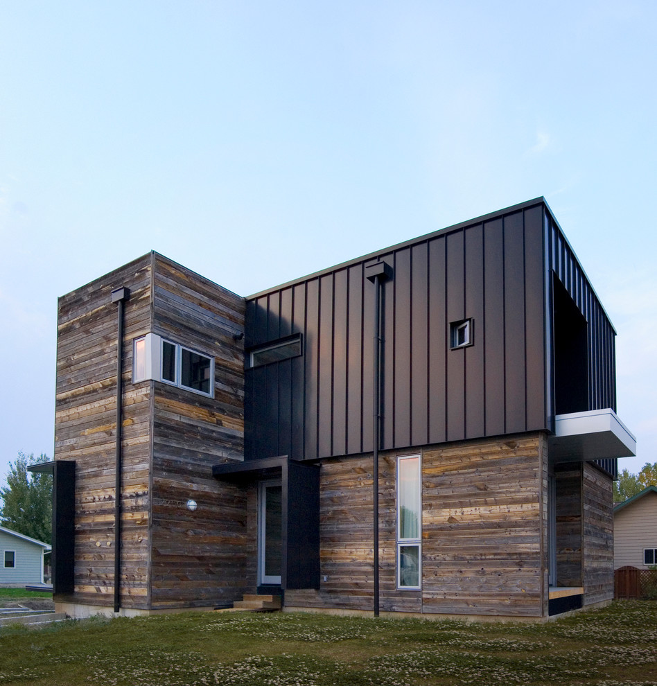 На фото: двухэтажный, коричневый дом среднего размера, из контейнеров в современном стиле с комбинированной облицовкой и плоской крышей